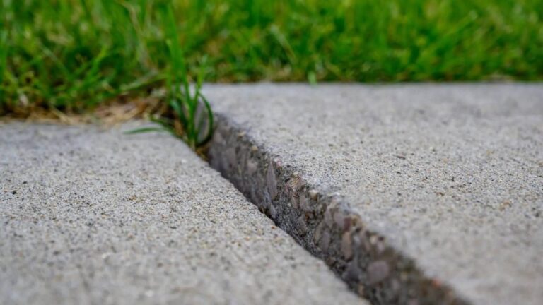Uneven sidewalk with a visible trip hazard gap between concrete slabs, highlighting the need for trip hazard removal and ADA compliance services.